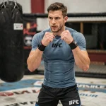 Combattant MMA professionnel en posture de combat dans une salle d'entraînement UFC, illustrant les catégories de poids et les prétendants au titre