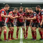 Équipe de rugby professionnelle en cercle tactique avant un match de Top 14 sur un terrain en herbe