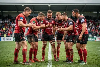 Équipe de rugby professionnelle en cercle tactique avant un match de Top 14 sur un terrain en herbe