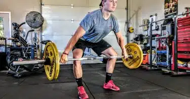 man carrying yellow barbell